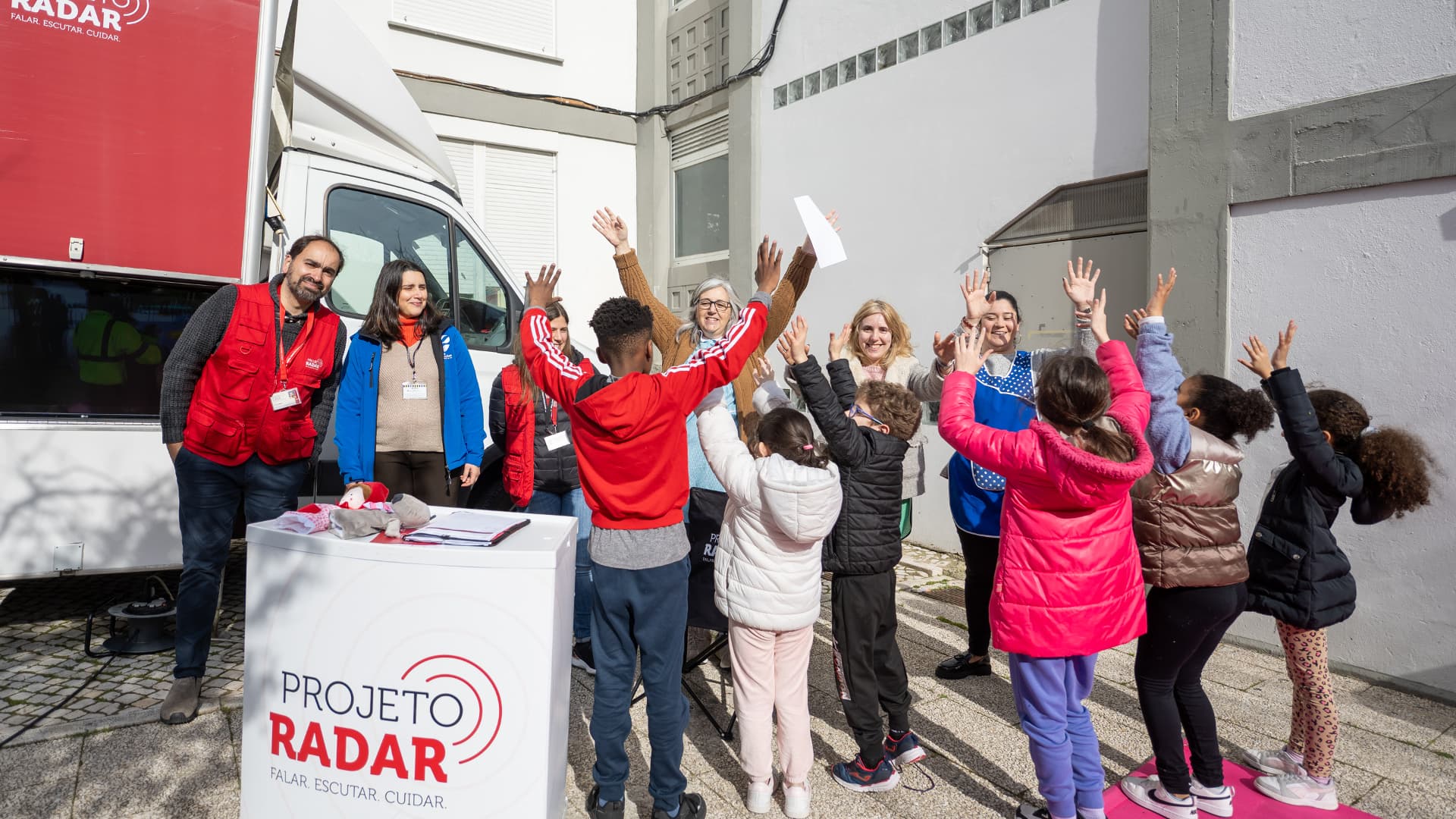 Jovens e voluntários do Radar felizes juntos da carrinha de rastreio